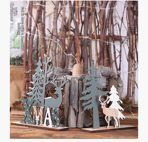 Detail of wooden XMAS table ornaments with reindeer and laser-cut tree designs