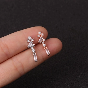 Macro shot of silver and rose gold star stud earrings with clear zircon stones on display