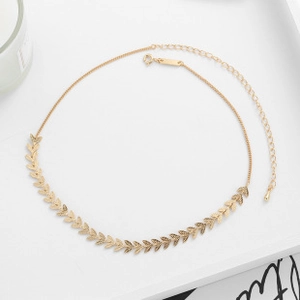 Detailed view of a gold leaf-shaped link necklace with an adjustable extender chain
