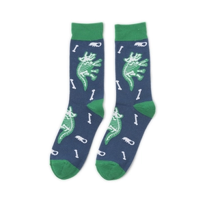 Detail of navy blue cotton socks featuring green triceratops fossil skeleton patterns
