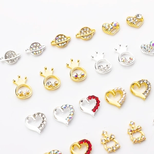 Macro detail of alloy nail charms with crowns, stars and hearts in gold and silver