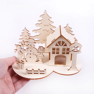Macro detail of laser-cut wooden Christmas scene DIY craft with house and snowman
