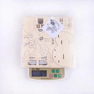 Flat lay of DIY wooden 3D Christmas puzzle kit with snowman and tree on white background