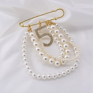 Elegant gold safety pin brooch with layered pearls and sparkling crystal number 5 charm