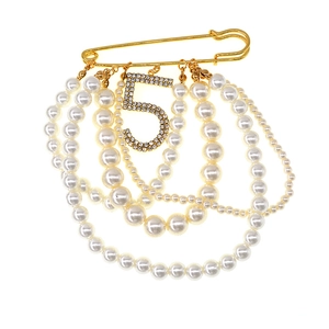 Elegant gold safety pin brooch with layered pearls and a sparkling crystal number five