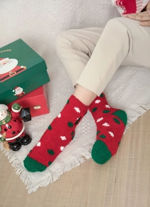Detailed close-up of thick red Christmas socks with white polka dots in soft coral fleece