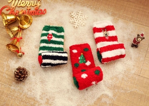 Three pairs of thick coral fleece Christmas socks with festive embroidery on snowy background