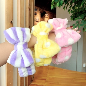 Close-up of soft plush bow headbands in purple stripes, yellow dots, and pink dots