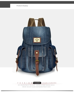 Dettaglio frontale dello zaino in denim blu con cinturini in pelle e chiusura in metallo