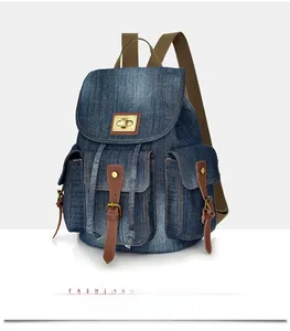 Dettaglio dello zaino vintage in denim con finiture in pelle marrone e chiusura girevole