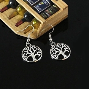 Silver Tree of Life dangle earrings on elegant black mirror background with vintage props
