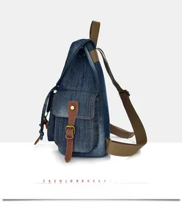 Dettaglio tasca laterale con fibbia in pelle marrone su zaino in denim stile vintage