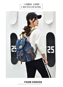 Dettaglio dello zaino in denim blu con inserti in pelle marrone e tracolla resistente
