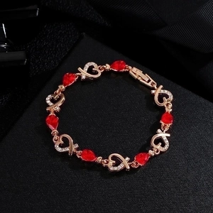 Elegant rose gold heart bracelet featuring red teardrop gems and sparkling crystals