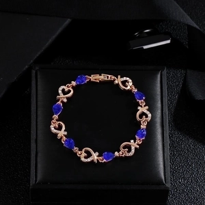 Rose gold heart bracelet with blue teardrop stones and zircon inlay on black velvet