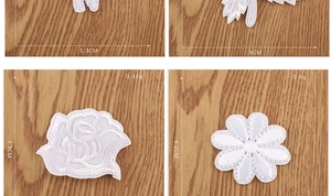 Detail view of white rose flower embroidered patches showing fine stitching texture