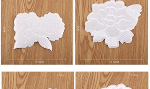 White lace floral embroidery patches for clothing repair on warm wood background