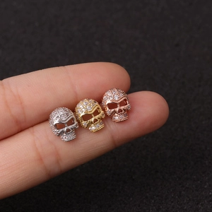 Skull cartilage earrings in silver, gold, and rose gold with zircon inlay on hand