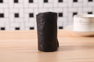 Close-up of a roll of black thickened plastic trash bags on a kitchen countertop