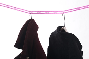 Detailed view of pink windproof clothesline with a multi-hole design for outdoor drying