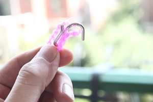 Detailed close-up of a sturdy metal hook on a pink anti-slip windproof clothesline