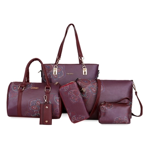 Deep burgundy 6-piece handbag set with paisley pattern and golden hardware on white background