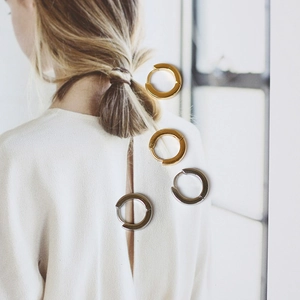 Minimalist chic 18K gold and silver titanium steel hoop earrings shown on a creative card