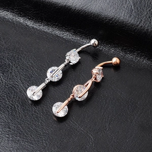 Detail view of silver and rose gold navel rings with three round sparkling cubic zirconia