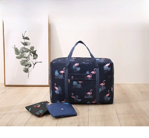 Foldable waterproof travel bag with flamingo print and luggage strap attachment