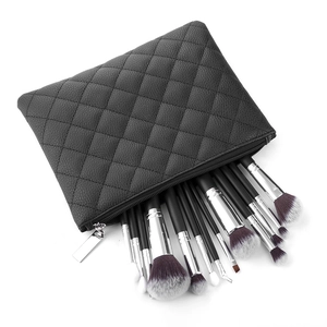 Detail of black quilted PU leather makeup bag with professional brush set inside