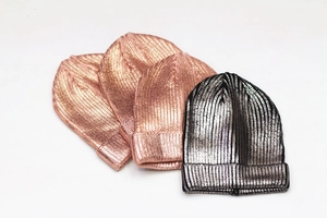 Detail of rose gold and silver metallic knit beanies with shimmering sequin texture