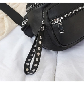 Detailansicht einer schwarzen PU-Bauchtasche mit silbernem Reißverschluss und Nieten