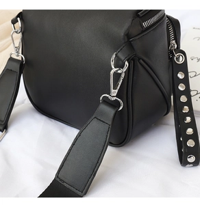 Detail der Silbernieten und Metallhaken an der minimalistischen schwarzen Ledertasche