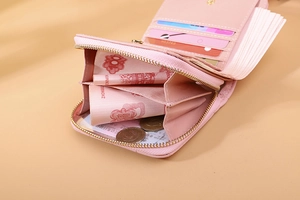 Detailed view of pink leather short wallet showing zip pocket, card slots and bill fold