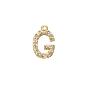 Macro shot of gold letter G pendant with micro-pave cubic zirconia on white background