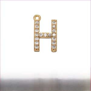 Macro view of gold brass letter H pendant with micro-pave zircons and 12mm size details