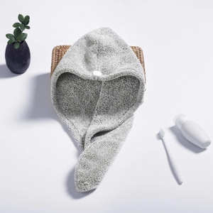 Detail of grey microfiber hair towel wrap with button closure on a woven basket