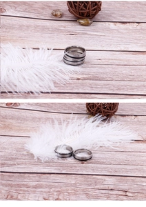 Detail view of silver and black striped stainless steel ring for men on rustic wood
