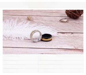 Detail of black and silver brushed titanium steel rings with gold plating and wood decor