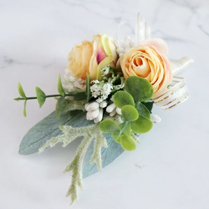Romantic bridal corsage with light orange silk roses and eucalyptus on marble background