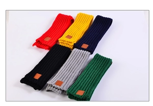 Detail view of multi-color knitted scarves with premium leather patches and textured finish