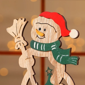 Close-up of wooden snowman ornament with red hat and green scarf on festive backdrop