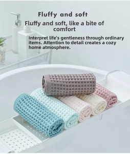 Detail of multi-colored waffle weave cotton towels neatly rolled on a bathroom shelf