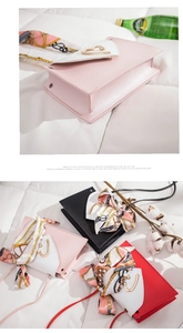 Close-up of stylish crossbody bags with silk scarves and heart-shaped gold buckles