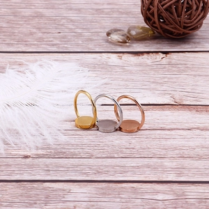 Three minimalist titanium steel rings in gold, silver and rose gold on a rustic wood background