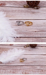Detailed close-up of gold and silver hugging hands open rings on a wooden texture background