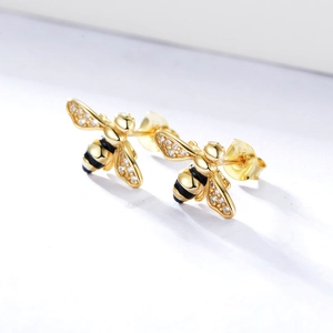 Detailed macro view of S925 silver bee stud earrings with gold plating and crystals