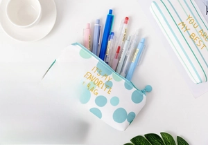 Detailed view of canvas pencil cases with gold-stamped quotes and varied patterns