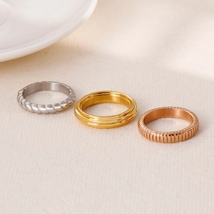 Three-piece stackable ring set in silver, gold, and rose gold with textured patterns