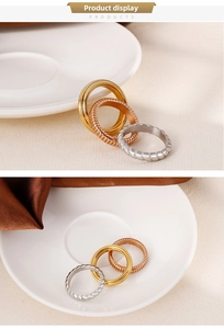 Detailed view of triple-colored stainless steel stacked rings in gold, silver, and rose gold